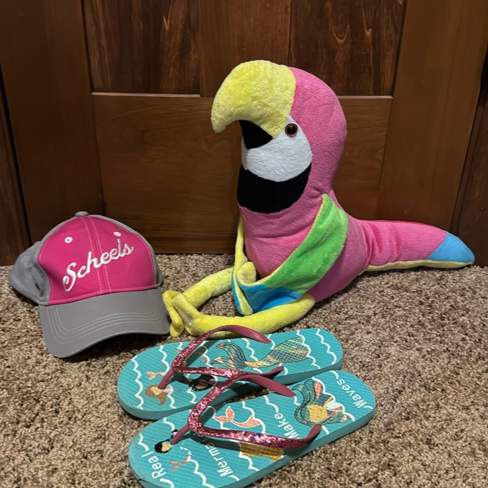 Scheels hat, mermaid flip flops and a parrot stuffed animal. .